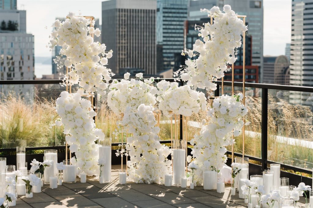 Rooftop surprise proposal in Seattle with white floral installation and city skyline