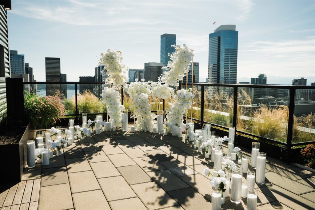 Rooftop surprise proposal in Seattle with white floral installation and city skyline