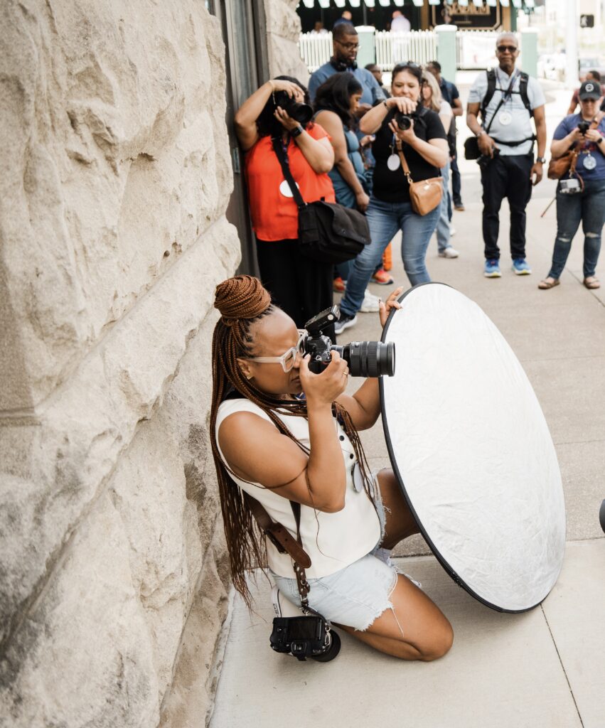 Photography educator Candace Connor demonstrating lighting techniques while teaching photographers during an in-person workshop