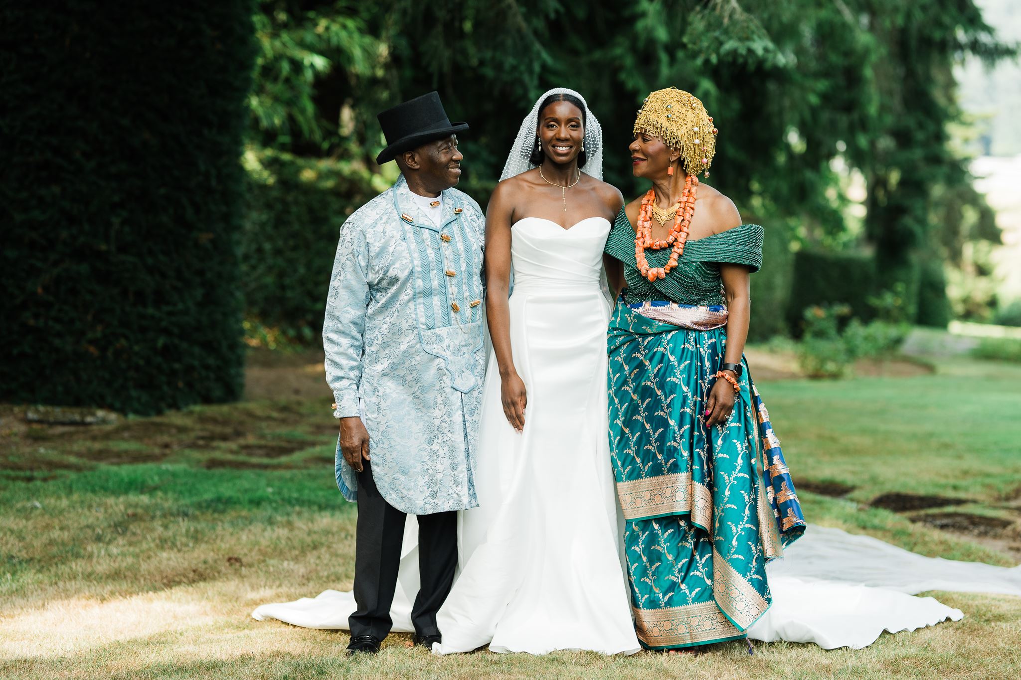Bride Poses with Mother and Father who are Wearing Traditional Nigerian Wedding Day Attire