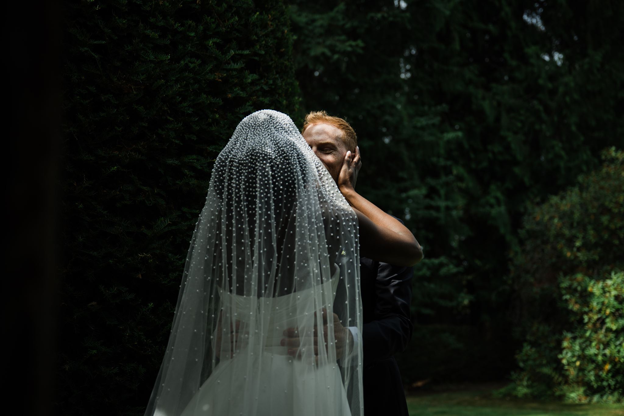 Bride and Groom Kiss in Gardens of Carnation Farms Venue